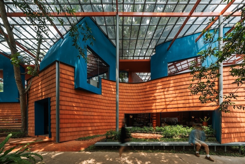 azure blue hues contrast with terracotta tiles on nusa kitchen pavilion’s facade in java