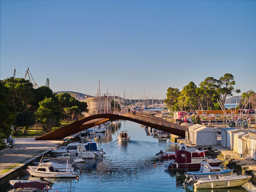 slender steel bridge with integrated net seating expands over foša port in croatia